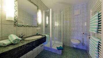 Une salle de bain avec deux lavabos, une douche et des toilettes.