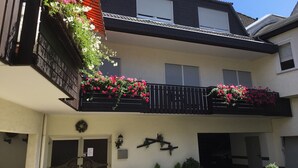 A two-story building with balconies adorned with flowers. - Hotel Zum Adler (Nidderau)