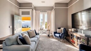 Uma sala de estar moderna com um sofá, uma televisão e uma mesa de centro.