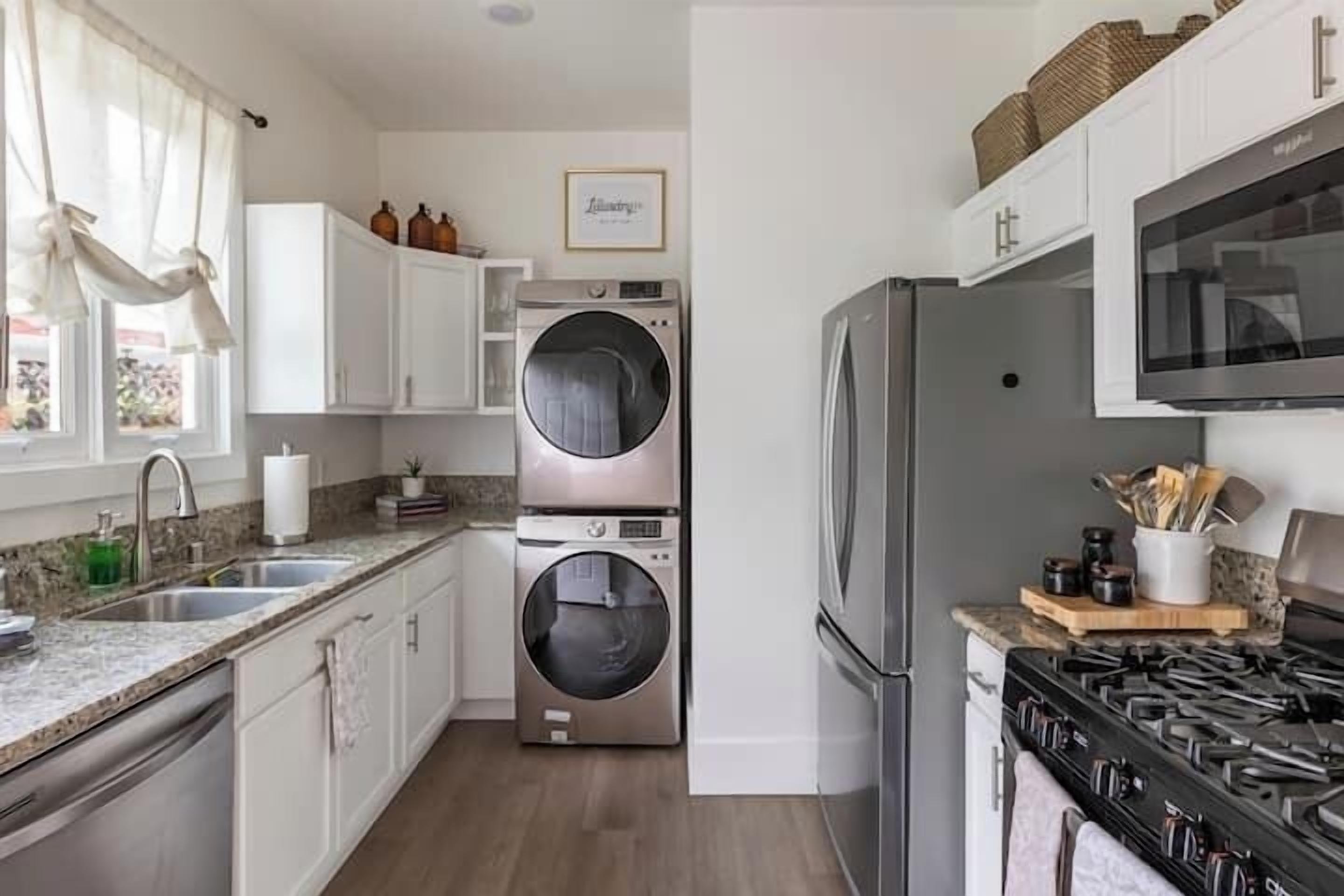 A modern kitchen with stainless steel appliances, a double oven, and a built-in washer and dryer.