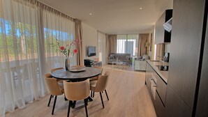 Una cocina moderna con comedor, sofá y televisión.