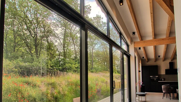 Un interior espacioso con ventanas amplias que dan a un exuberante jardín.