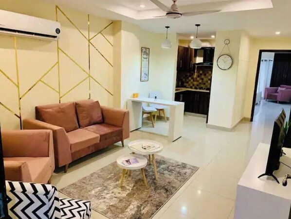 Relax in this stylish living room with a beige sofa, geometric-patterned throw pillow, and patterned rug.