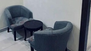 Un cuarto pequeño y cerrado con dos sillones y una pequeña mesa redonda.