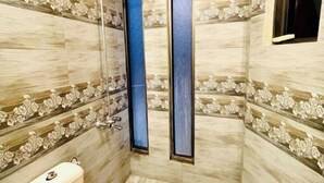 Un baño pequeño con inodoro, ducha y ventana.