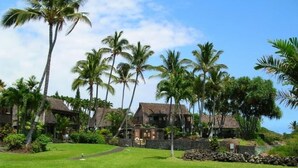 A resort with multiple buildings, a well-maintained lawn, and palm trees. - #26 Colony One at Sea Mt. Punalu`u (Pahala)