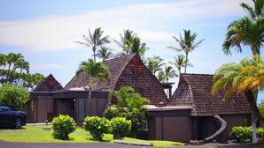 A resort with multiple buildings featuring steeply pitched roofs, surrounded by lush greenery and palm trees. - #26 Colony One at Sea Mt. Punalu`u (Pahala)