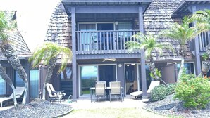 A two-story building with a balcony, outdoor seating area, and palm trees. - #16 2 bed/2 bath Two Story Condo with Stunning Oce (Pahala)