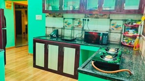 A kitchen with wooden cabinets, a microwave, a gas stove, and a sink.