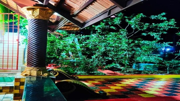 A night scene with a checkered floor, a column with a rope-like texture, and greenery in the background.