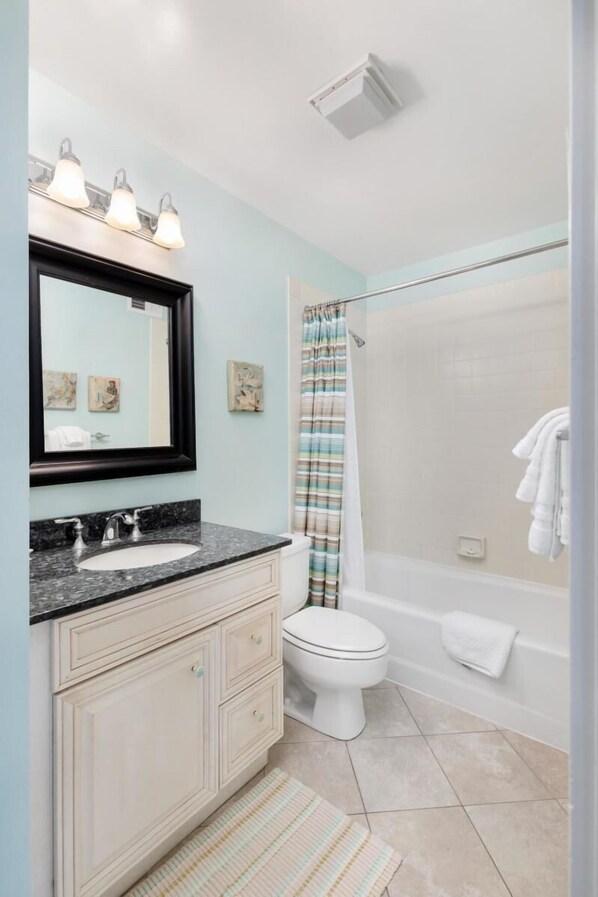 A bathroom with a sink, mirror, and toilet.