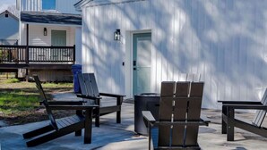 A patio with outdoor furniture, a trash can, and a building with a door and windows. - The Modern Historic Gem | Just minutes to Downtown (West Columbia)