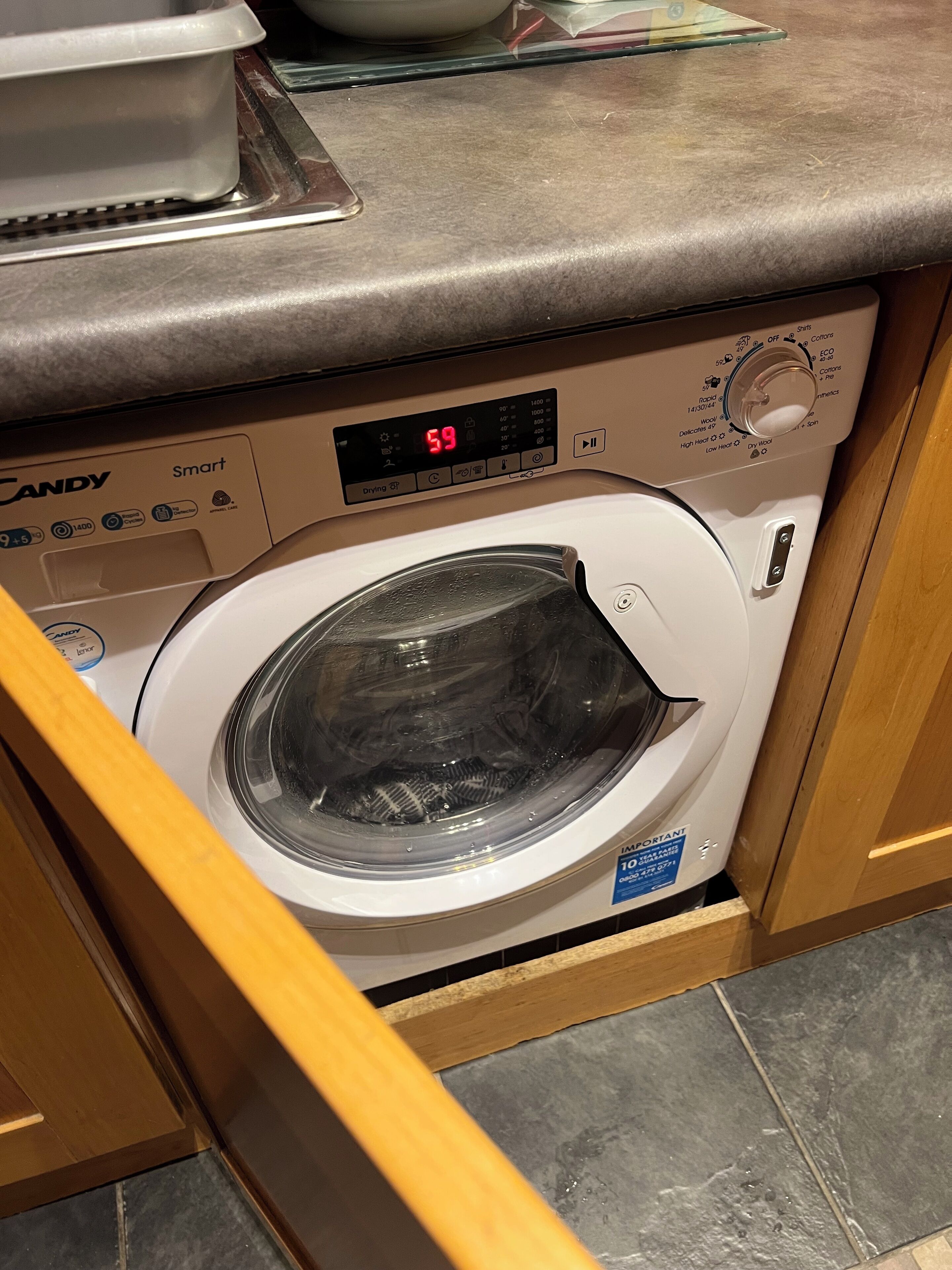 Une machine à laver à chargement frontal dotée d’un écran numérique, d’un panneau de commande et d’une étiquette indiquant qu’il s’agit d’un modèle important.