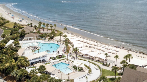 A resort with a large pool area, beach access, and palm trees. - Seabrook Exclusives | 1302 Pelican Watch (Seabrook Island)