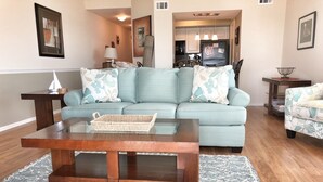 A living room with a sofa, a coffee table, and a small side table. - Seabrook Exclusives | 1302 Pelican Watch (Seabrook Island)