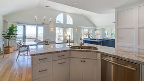 A spacious kitchen with a large island, built-in cabinets, and a dishwasher.