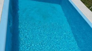 Ein klares, blaues Schwimmbecken mit einer Spielzeugfigur in der Ecke.