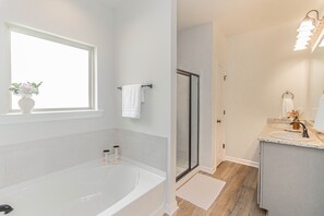 Een bad/douchecombinatie, een haardroger, handdoeken, toiletpapier