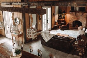 A cozy living room with a fireplace, leather sofa, and wooden furniture.