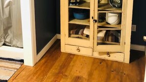 A corner room with a wooden cabinet, a painting, and a blue bowl on top. - Ever After <br>Lakefront Splendor (Florence)