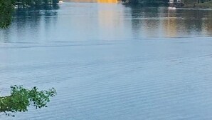 A calm lake with a forested shoreline and a small building on the right. - Ever After <br>Lakefront Splendor (Florence)