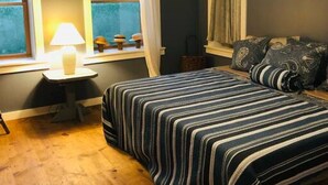 A bedroom with a bed, a nightstand, a window with curtains, and a ceiling fan. - Ever After <br>Lakefront Splendor (Florence)