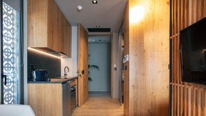 A modern kitchen with wooden cabinetry, a built-in oven, and a coffee maker. - Souda Plaza Collection (Chania)