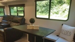 Une pièce chaleureuse avec une table verte, un coussin blanc orné du mot « BLESSED » et une pancarte indiquant « CLEVELAND ».