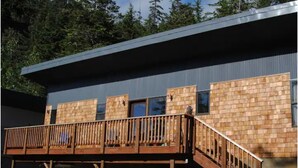 A modern building with a wooden deck and a metal roof. - Modern 2 bedroom. Minutes airport & ferry (Juneau)