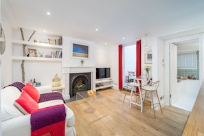 Cozy living space with a fireplace, flat-screen TV, and dining area.