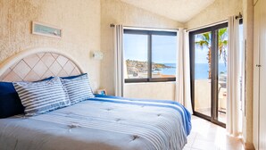 A bedroom with a bed, a view of the sea, and a balcony. - Peaceful ocean-view condo in an oceanfront community with private beach access! (Cabo San Lucas)