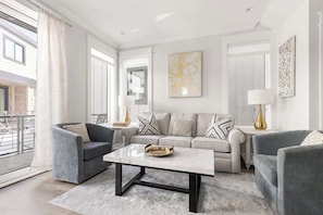A modern living room with a sofa set, a coffee table, and a view of the outside.