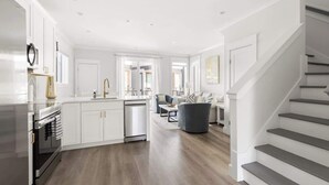 A modern kitchen with white cabinetry, a built-in oven, and a dishwasher.