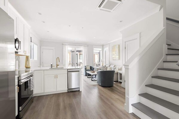 A modern kitchen with white cabinetry, a built-in oven, and a dishwasher.