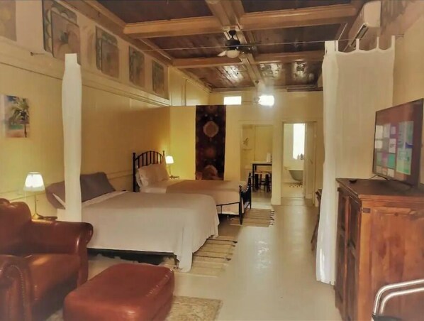 Relax in a traditional room with a large bed, two armchairs, and a TV.