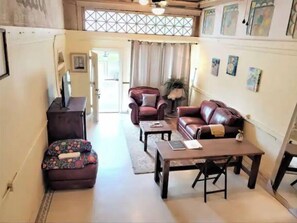 Relax in this stylish living room with a comfortable sofa, armchairs, and a large window offering a view of the outdoors.
