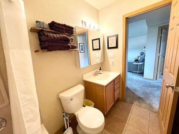 Un baño pequeño con inodoro, lavamanos y un perchero para toallas.