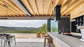 A modern kitchen with a large window overlooking a scenic landscape. - Luxurious 4-BR villa for up to 8 with pool and spa (Golubići)