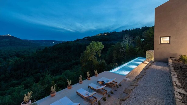 A modern outdoor pool area with lounge chairs and potted plants, overlooking a mountainous landscape at dusk. - Luxurious 4-BR villa for up to 8 with pool and spa (Golubići)