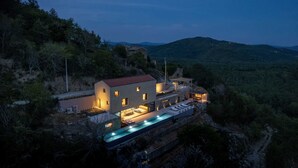 A modern house with a swimming pool, surrounded by hills and trees. - Luxurious 4-BR villa for up to 8 with pool and spa (Golubići)