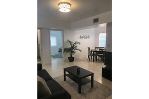 Relax in this stylish living room with a black coffee table, two sofas, and a potted plant.