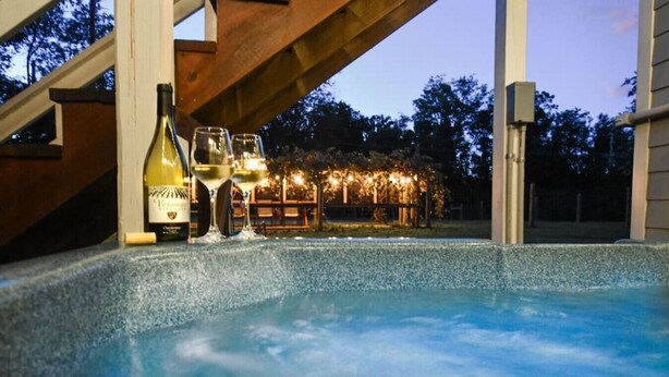 Ein Bereich mit Whirlpool, einer Holzbeschattung, einer Flasche und Gläsern.
