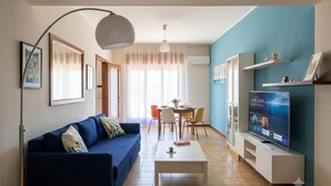 A living room with a sofa, coffee table, TV, and dining area. - Vacation home IL NIDO (Aeolian Islands boarding) WiFi/park free. CIR 19083049C21 (Milazzo)