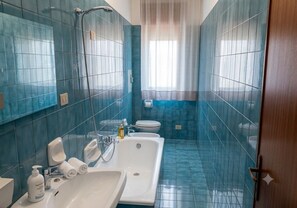 A bathroom with a large bathtub, a sink, and a toilet. - Vacation home IL NIDO (Aeolian Islands boarding) WiFi/park free. CIR 19083049C21 (Milazzo)