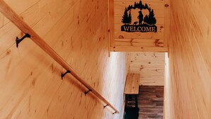 A wooden interior with a 'WELCOME' sign featuring a forest scene.