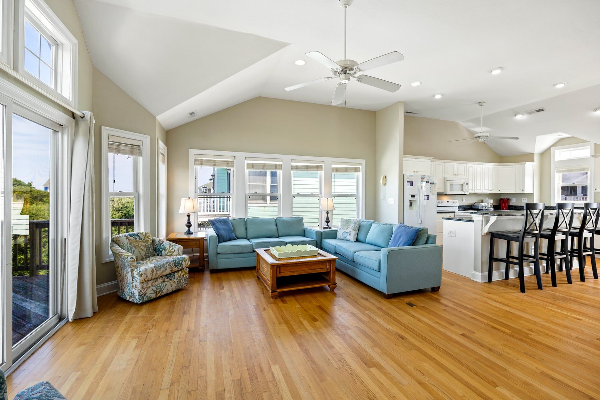 A spacious living room with a large sofa, a coffee table, and a dining area with chairs.