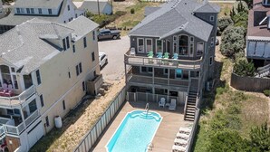 A two-story building with a swimming pool and outdoor seating. - 6067 The Sand Pebble *Pool *Game Rm *Dog Friendly (Nags Head)
