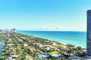 A coastal cityscape with a marina, beachfront properties, and a high-rise building.