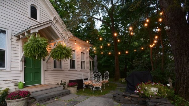 A house with a green door, outdoor seating, and string lights. - Locktender Cottage · Historic cottage near Mohonk & Minnewaska, 2BR/2BA (High Falls)