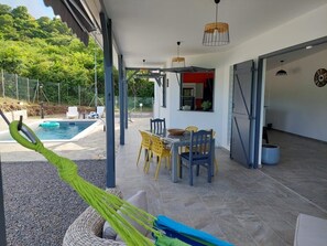 An outdoor patio with a pool, dining area, and a hammock. - Magnifique Villa Neuve Avec Piscine (Le Marin)